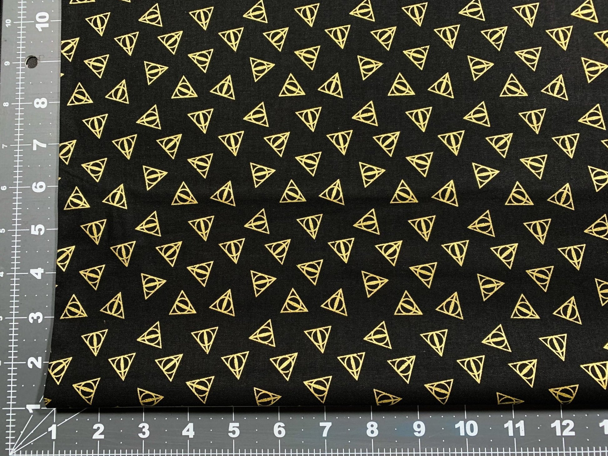 Harry Potter fabric Gold Metallic Deathly Hallows Logo - Mary Jo Fabrics