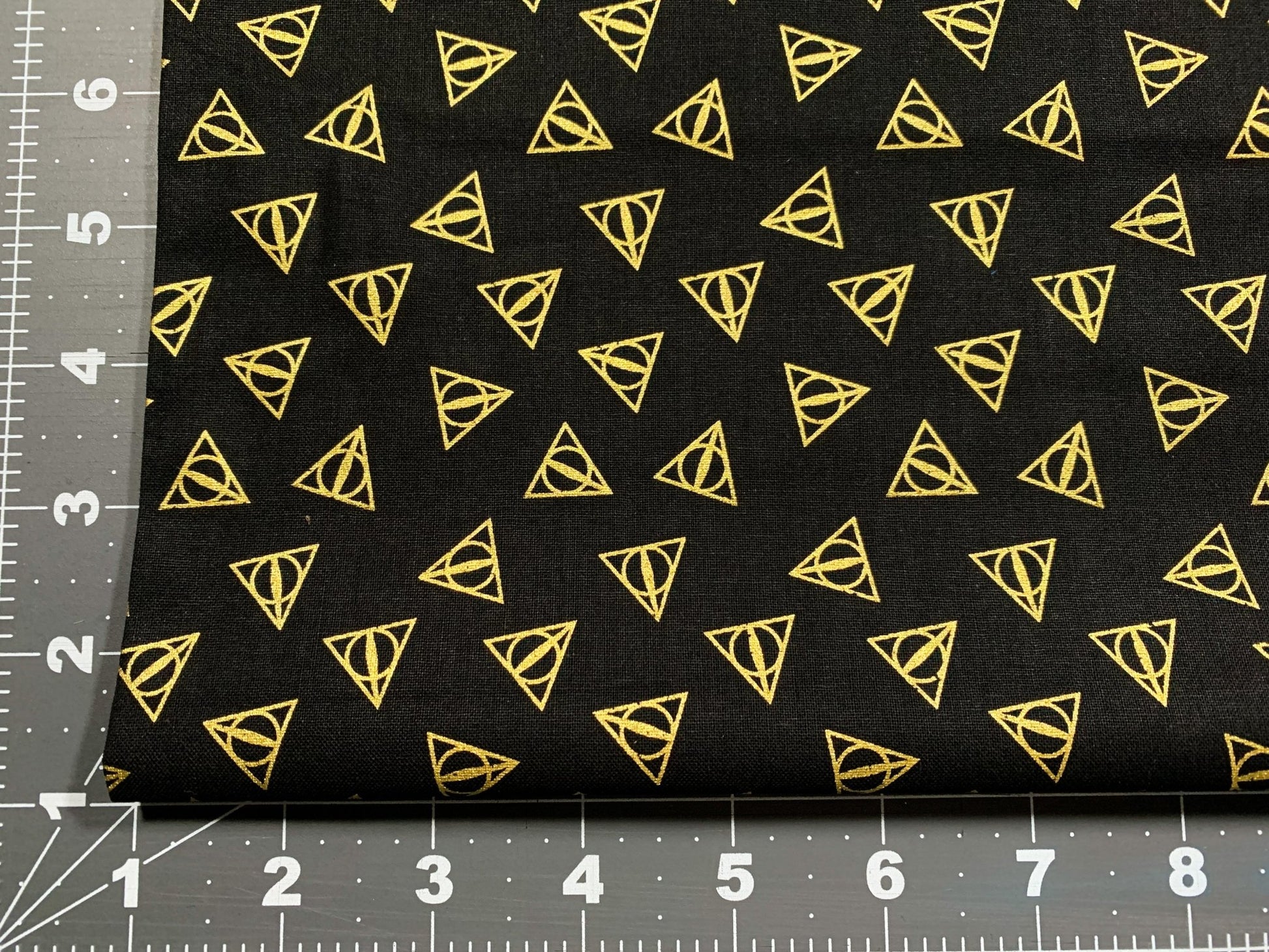 Harry Potter fabric Gold Metallic Deathly Hallows Logo - Mary Jo Fabrics